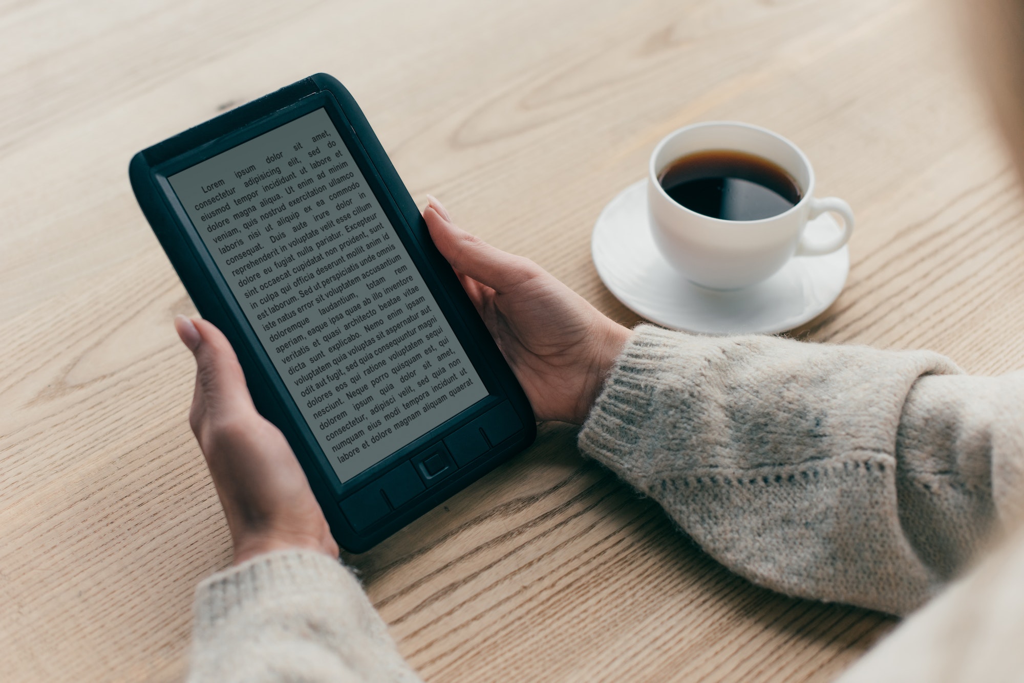 cropped view of woman studing with e-book near cup of coffee